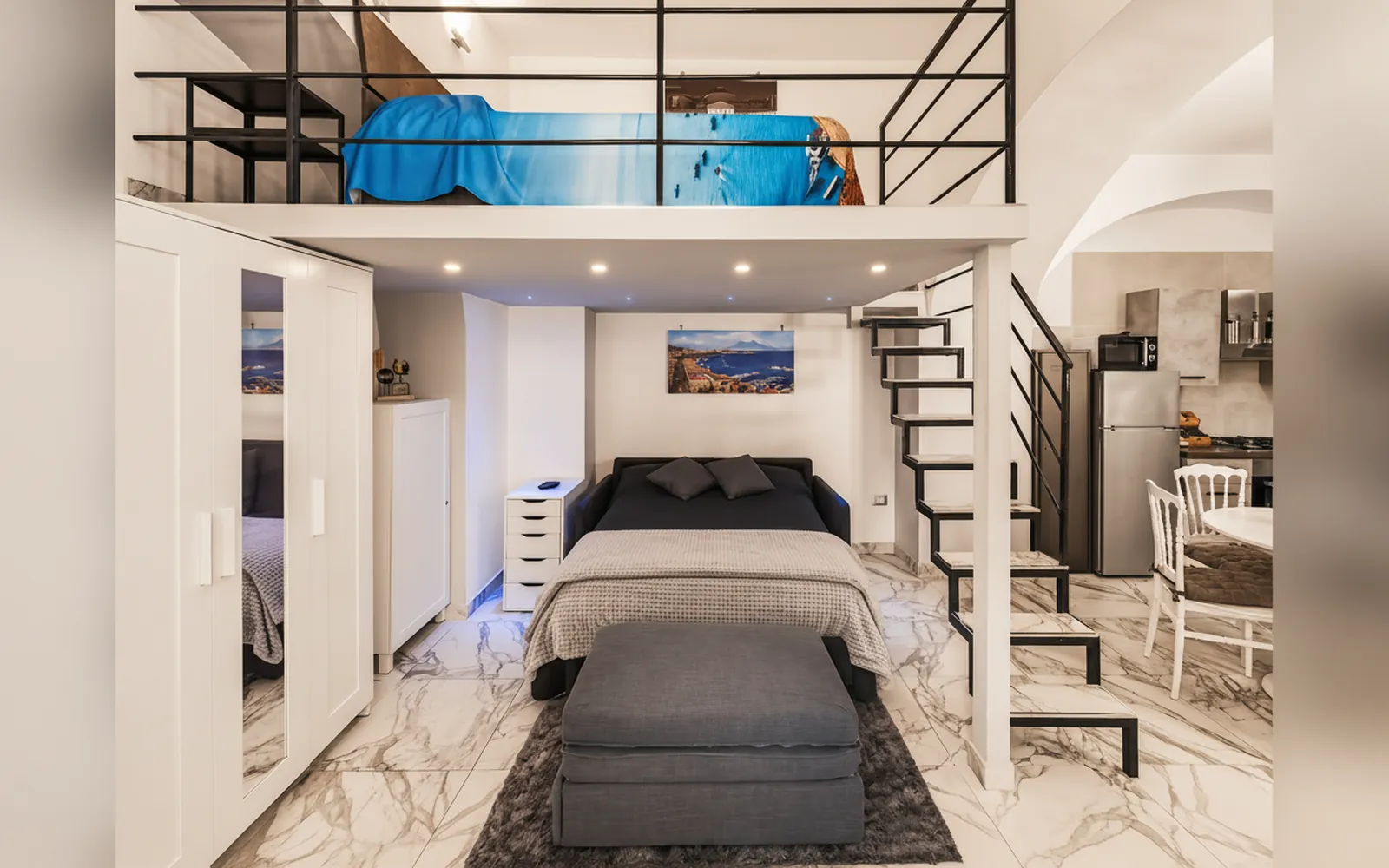 Zona giorno con divano letto e letto matrimoniale nella parte rialzata