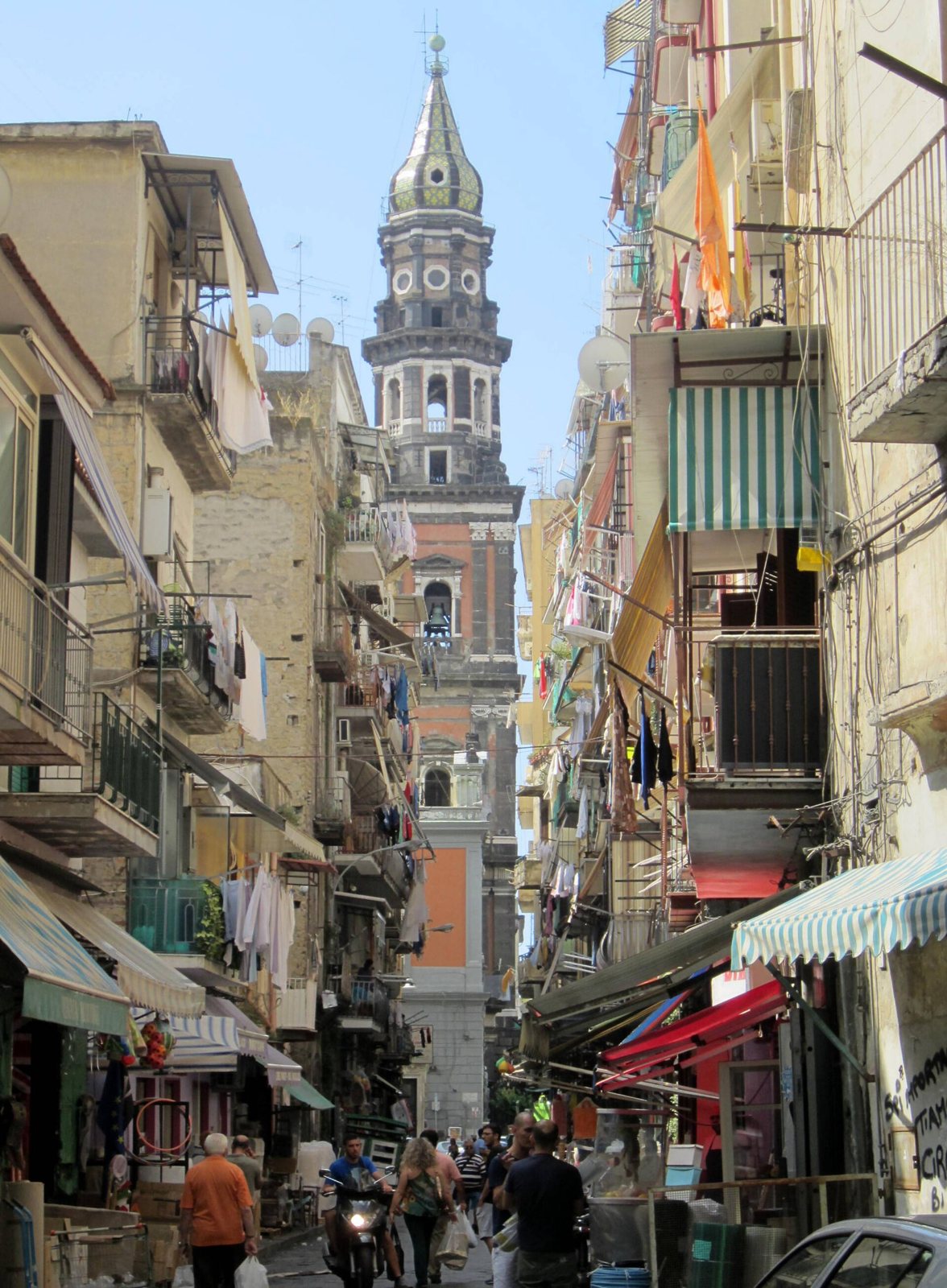 Campanile della Basilica del Carmine Maggiore a Napoli visto da via Lavinaio, tra palazzi con balconi e tende