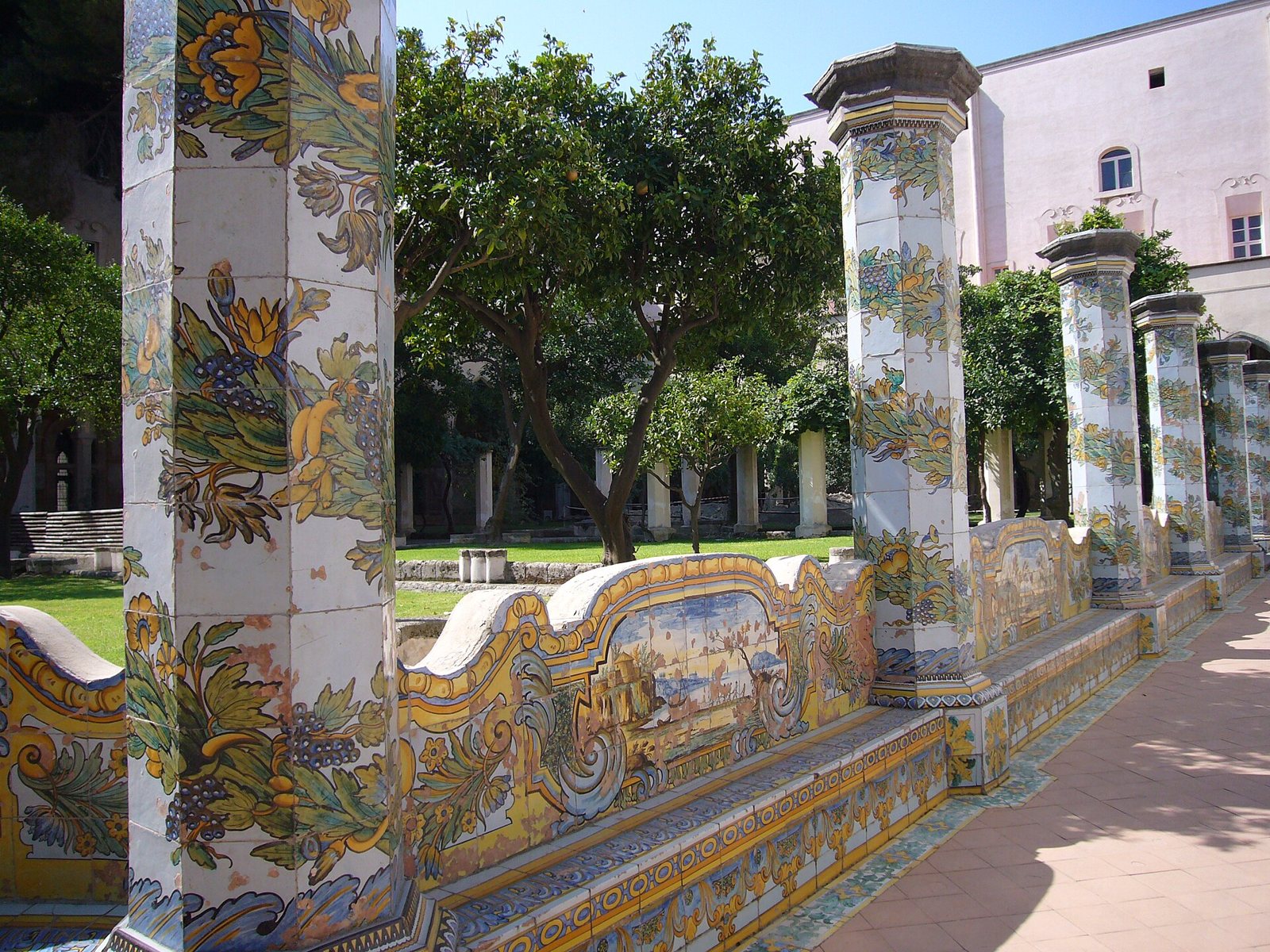 Chiostro maiolicato di Santa Chiara a Napoli, con pilastri e sedili rivestiti di maioliche colorate e alberi di agrumi