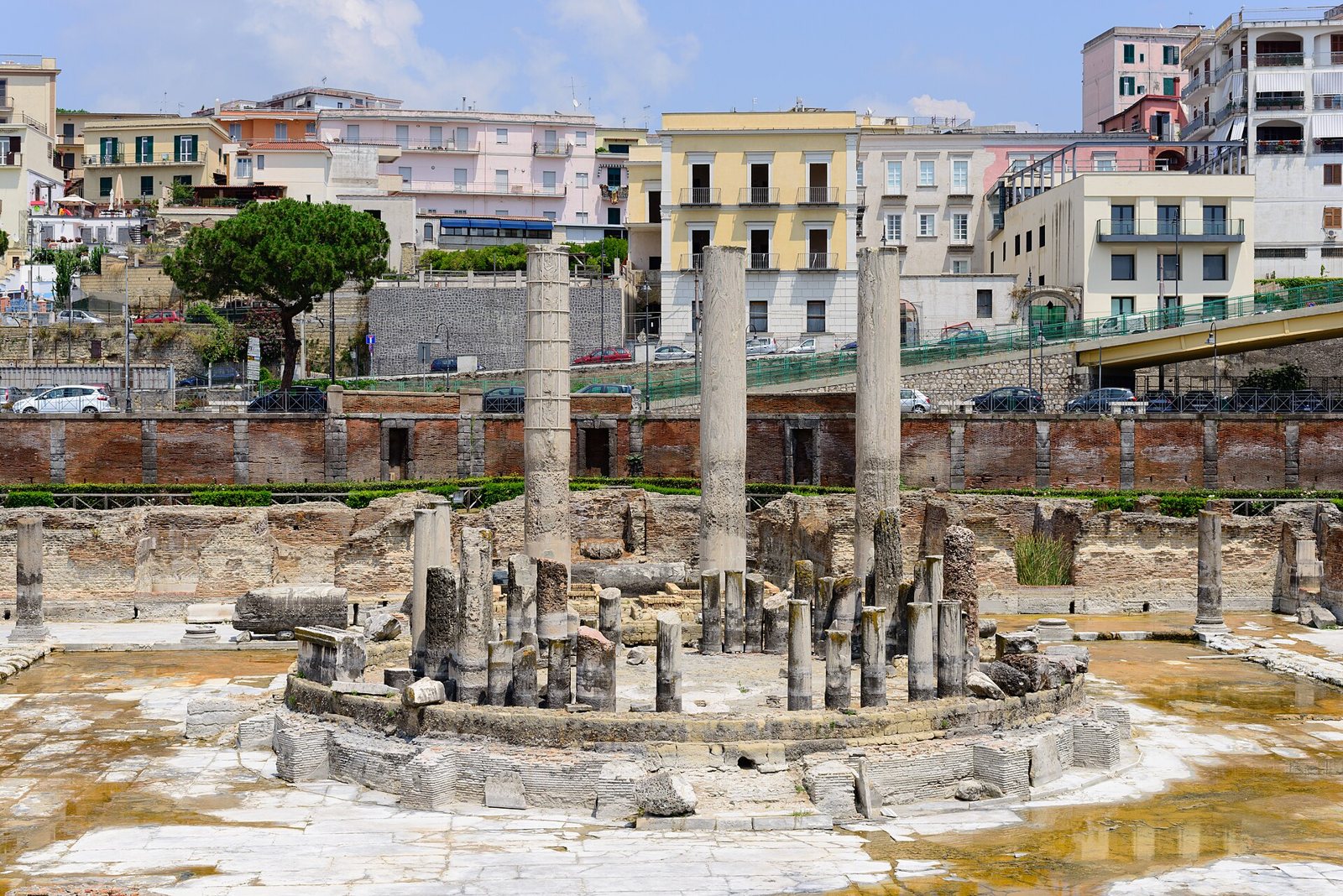 Il Macellum di Pozzuoli, detto Tempio di Serapide, con le tre grandi colonne e la struttura circolare centrale tra i resti romani